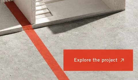 Close-up of a vermilion line on a plaster floor running past the red Explore the project button