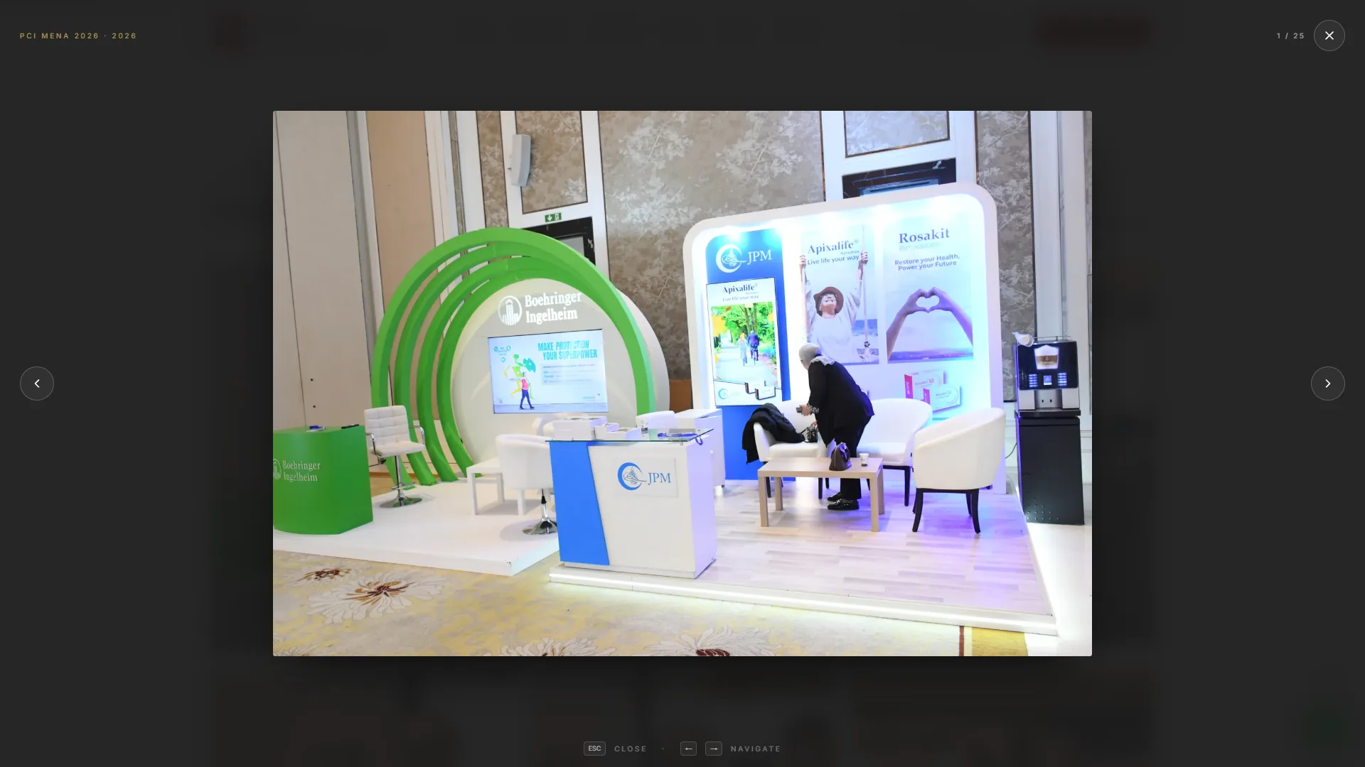 JVCES lightbox over the PCI MENA 2026 spread: an exhibition stand photograph with previous and next arrows and keyboard hints