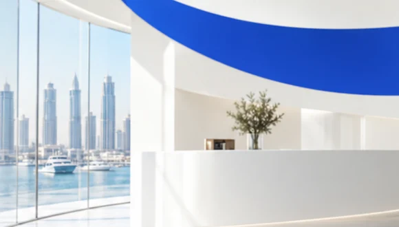 Close-up of the reception: curved windows onto towers and yachts, a white desk and a cobalt stripe on the ceiling.
