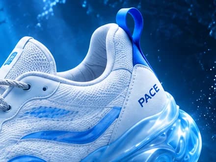 Pace design close-up: heel of a white knit sneaker with a blue pull loop, PACE print and a glowing translucent sole