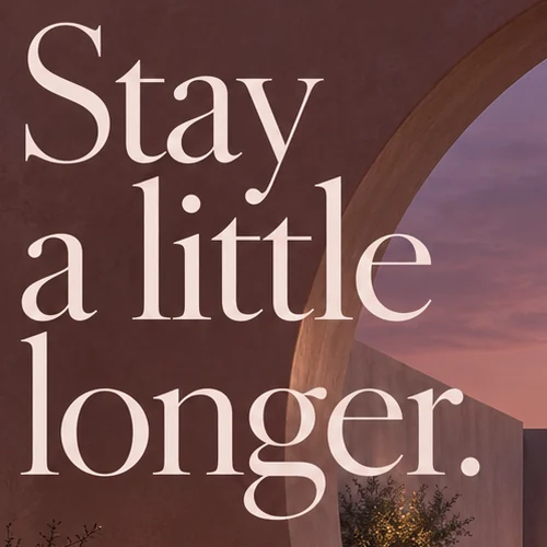Close-up of Stay a little longer. in a cream serif on clay plaster beside the arch
