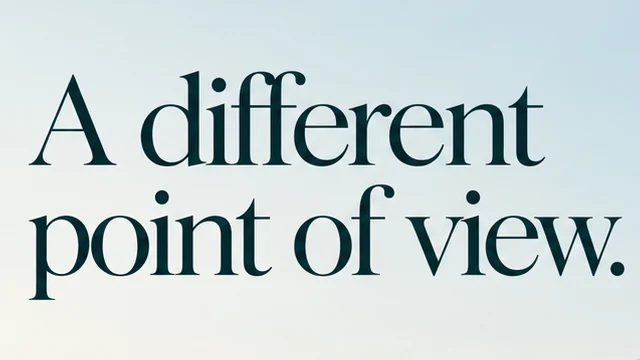 Close-up of the deep teal serif headline A different point of view. against pale blue sky